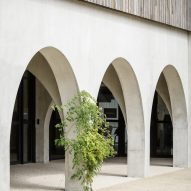 Arches in a concrete building with timber cladding on the upper level