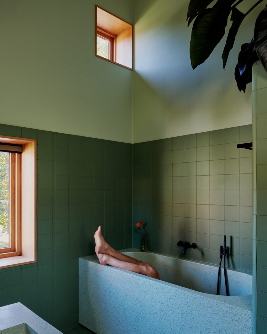 Bathroom with green tiles and terrazzo bath and basin