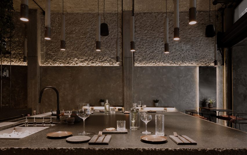 Cylindrical concrete pendants lamps hanging above a dining area