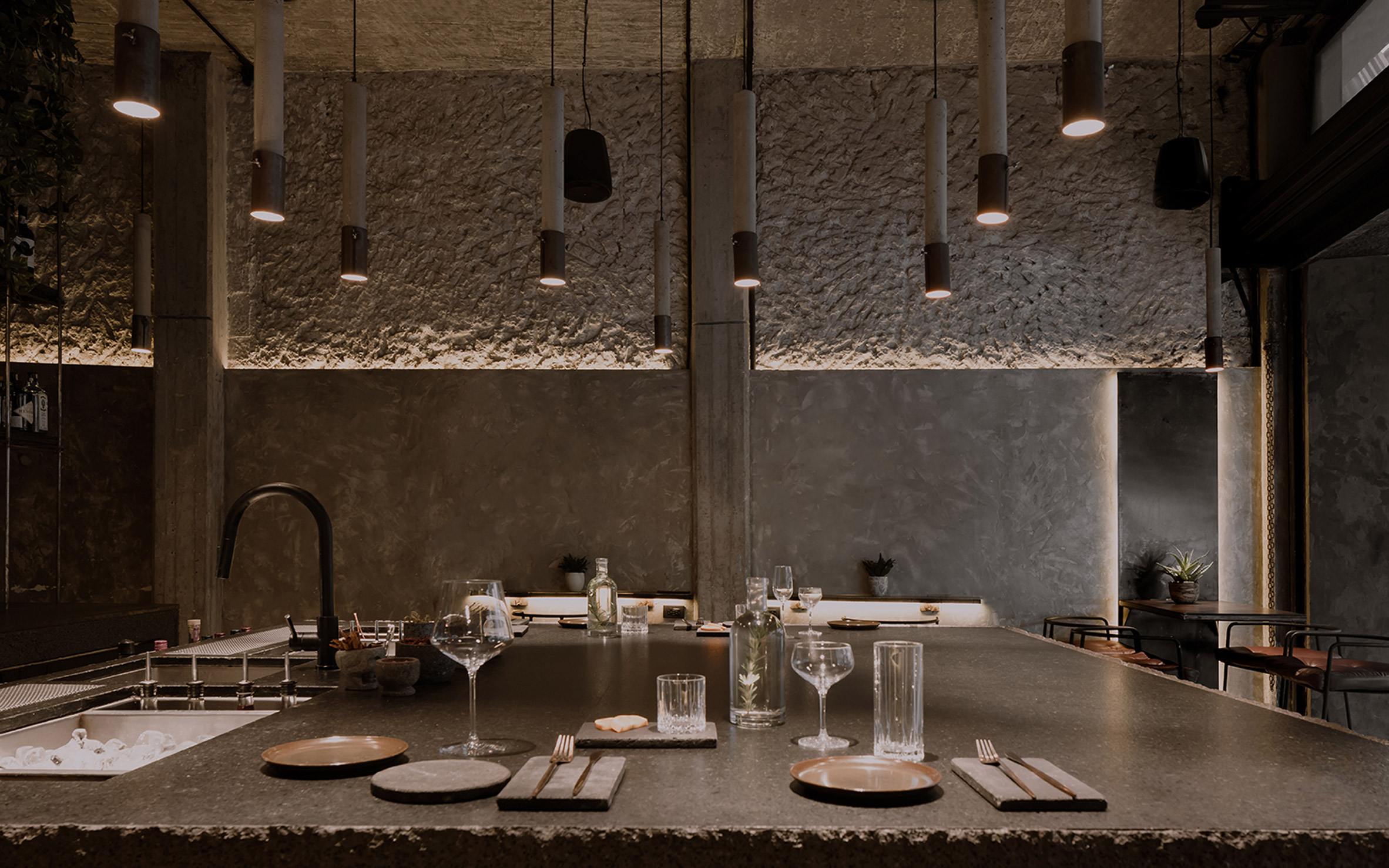 Cylindrical concrete pendants lamps hanging above a dining area