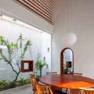 Dining room with a planted courtyard at Tile House by The Bloom Architects