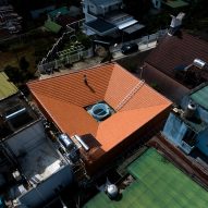 Aerial view of Tile House with a sloping red-tiled roof by The Bloom Architects