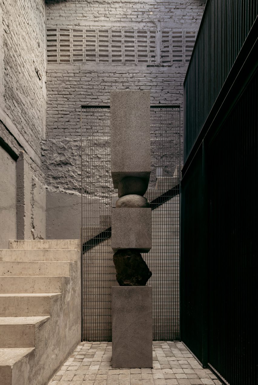 A staircase up to a mezzanine level winds around a totemic sculpture