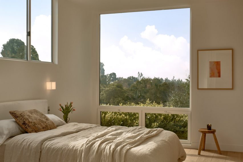 Bedroom with a large window overlooking treetops