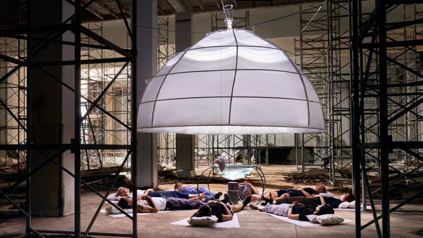 Photo of people lying under a lighting installation