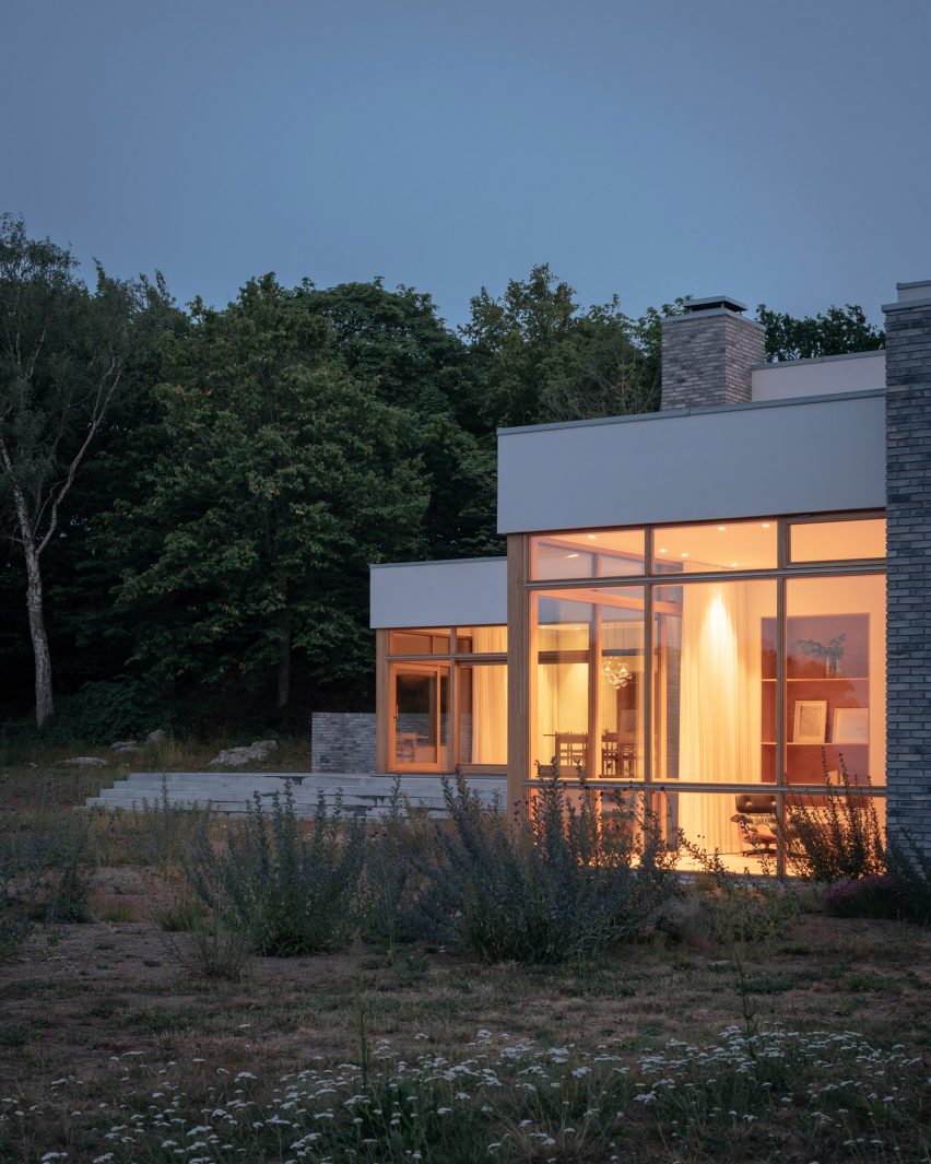 Dusk exterior view of blocky white home in Sweden by Asa Hjort Architects