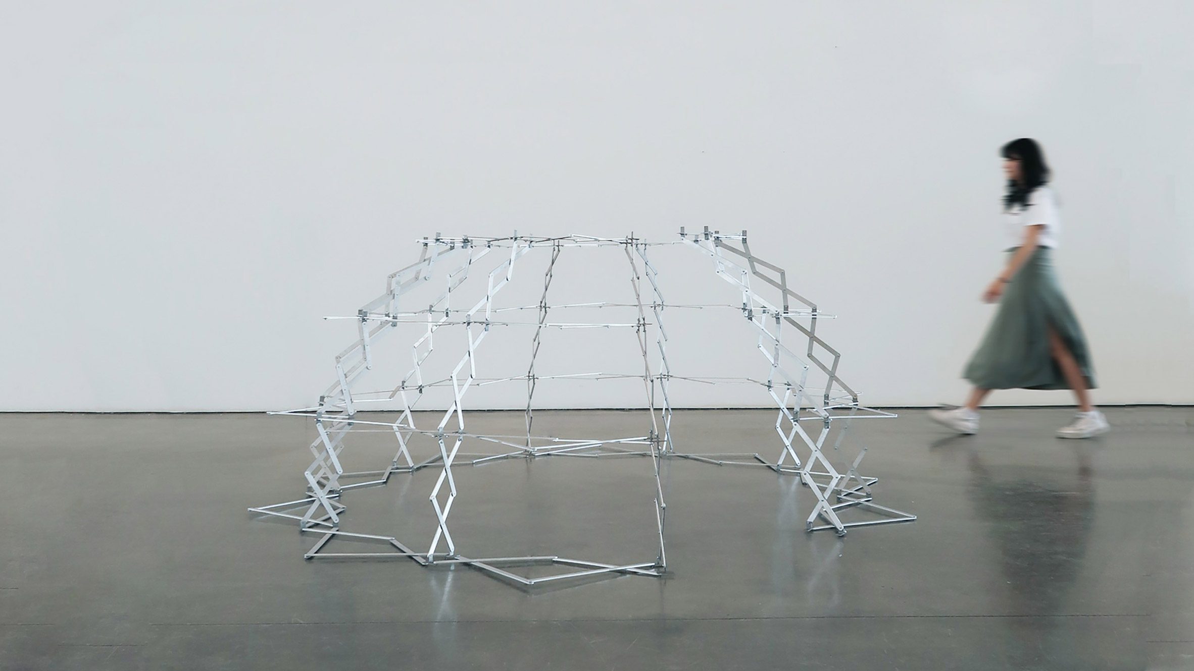 Figure walking past structure made from bending metal components