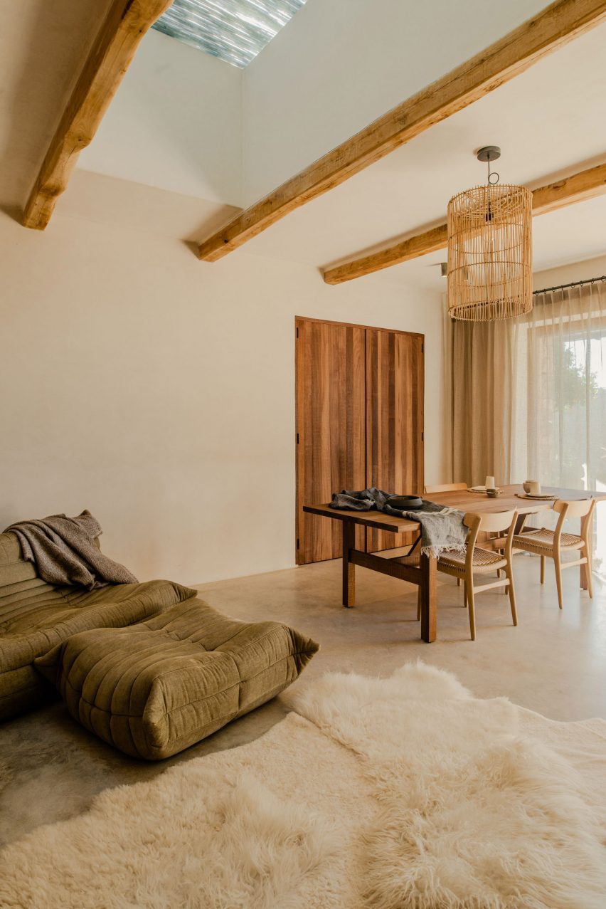 Room with wooden ceiling beams, polished concrete floor and a dining table