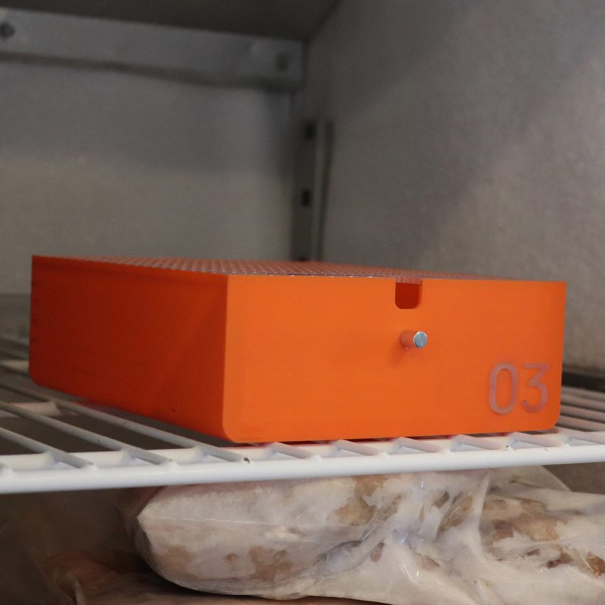 A bright orange drawer in a freezer