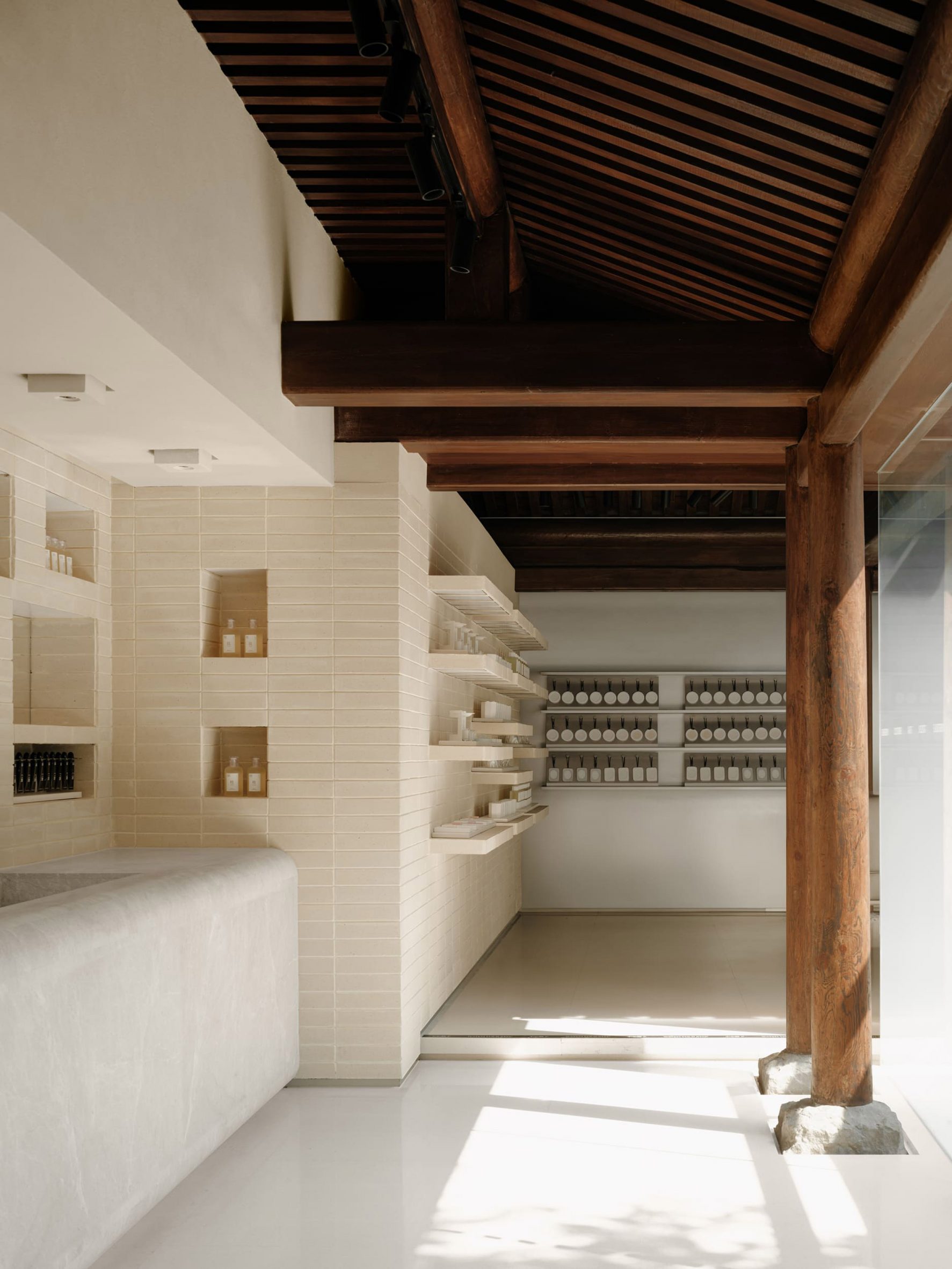 Interior of To Summer store with clay brick walls and shelves lined with fragrances