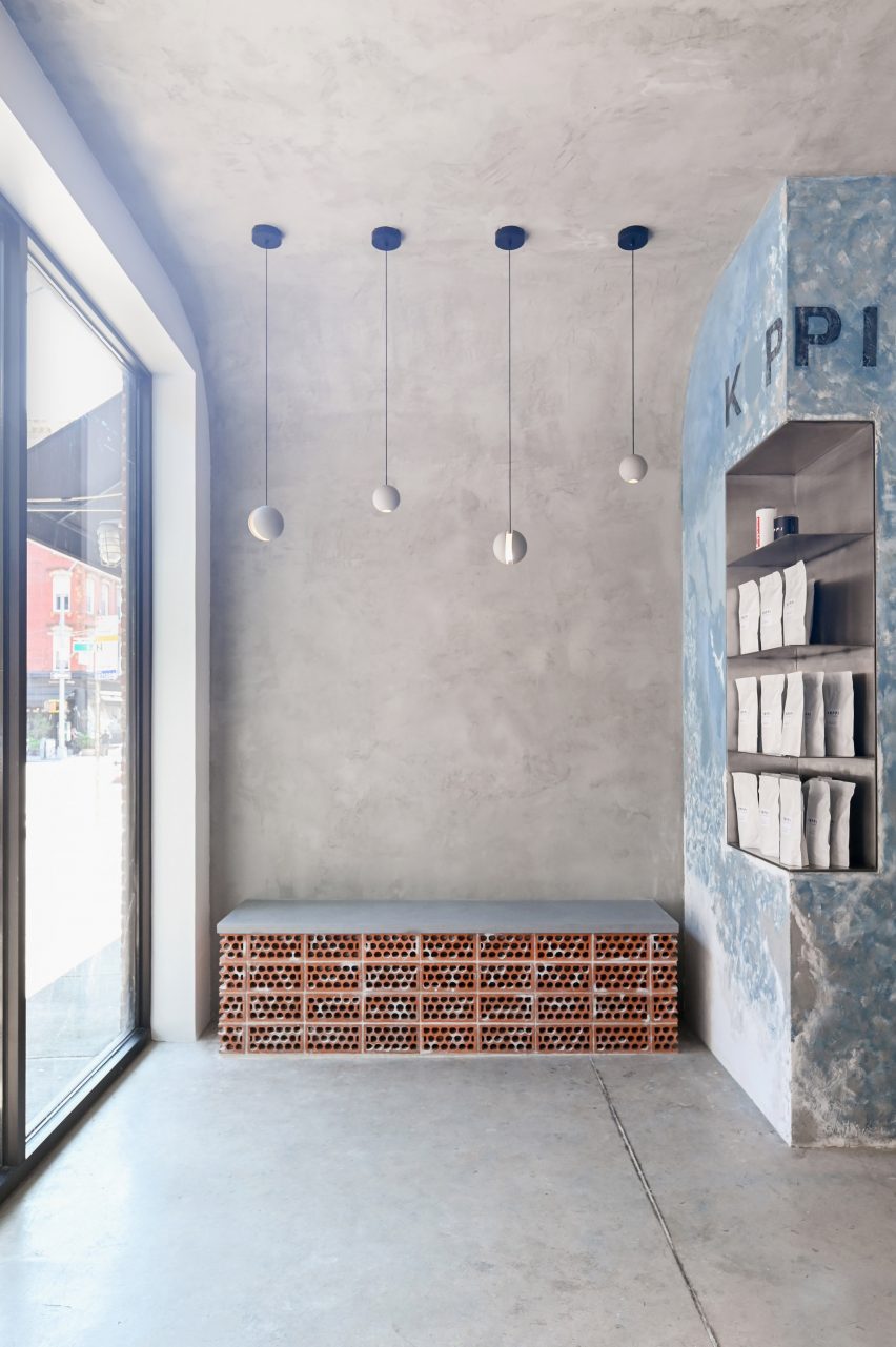 Concrete interior with small brick bench a،nst a wall