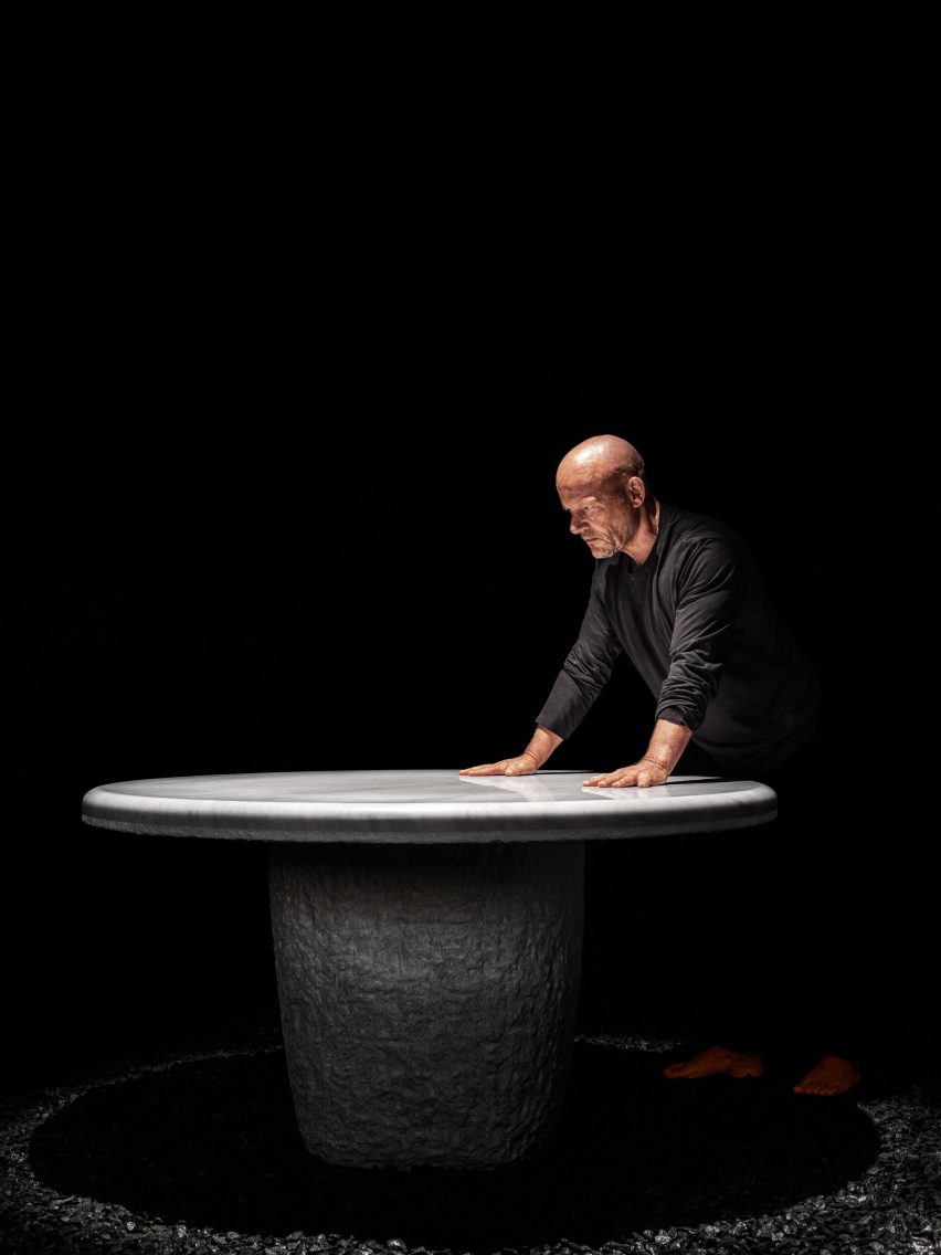 Vincent van Duysen stands atop a stone table