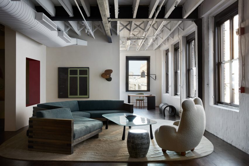 Room with exposed ceiling beams, whitewashed brick and dark wood floors