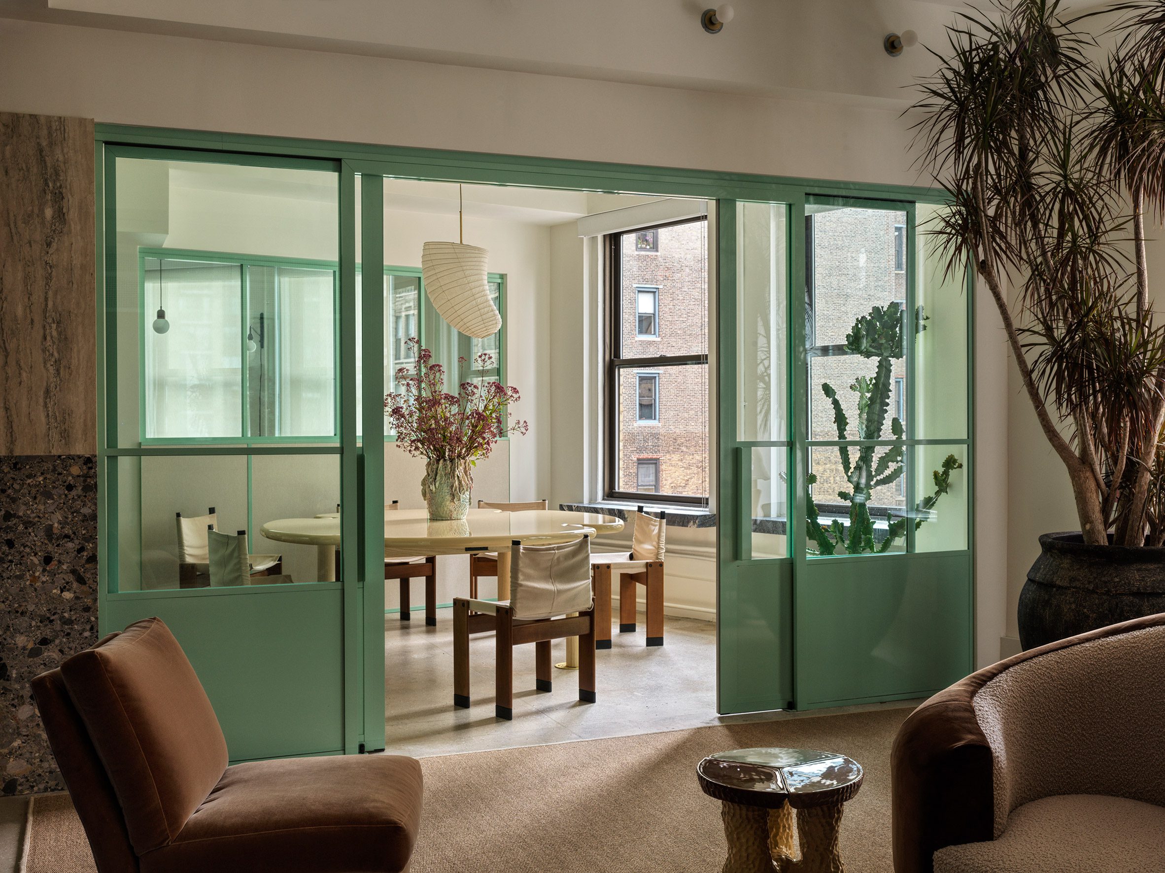 Office reception with meeting room visible through glass and mint green sliding doors