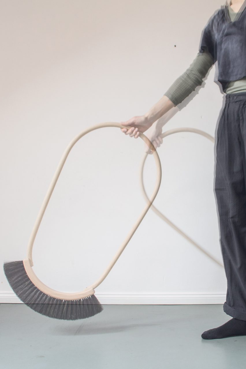 a person holding a broom with an oval handle