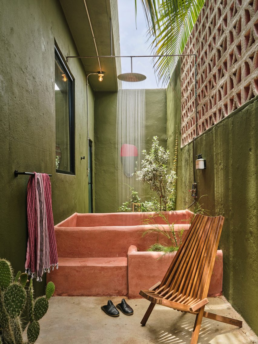 Outdoor pink concrete tub and rain shower