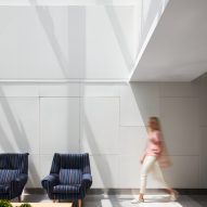 a woman walking by navy blue chairs