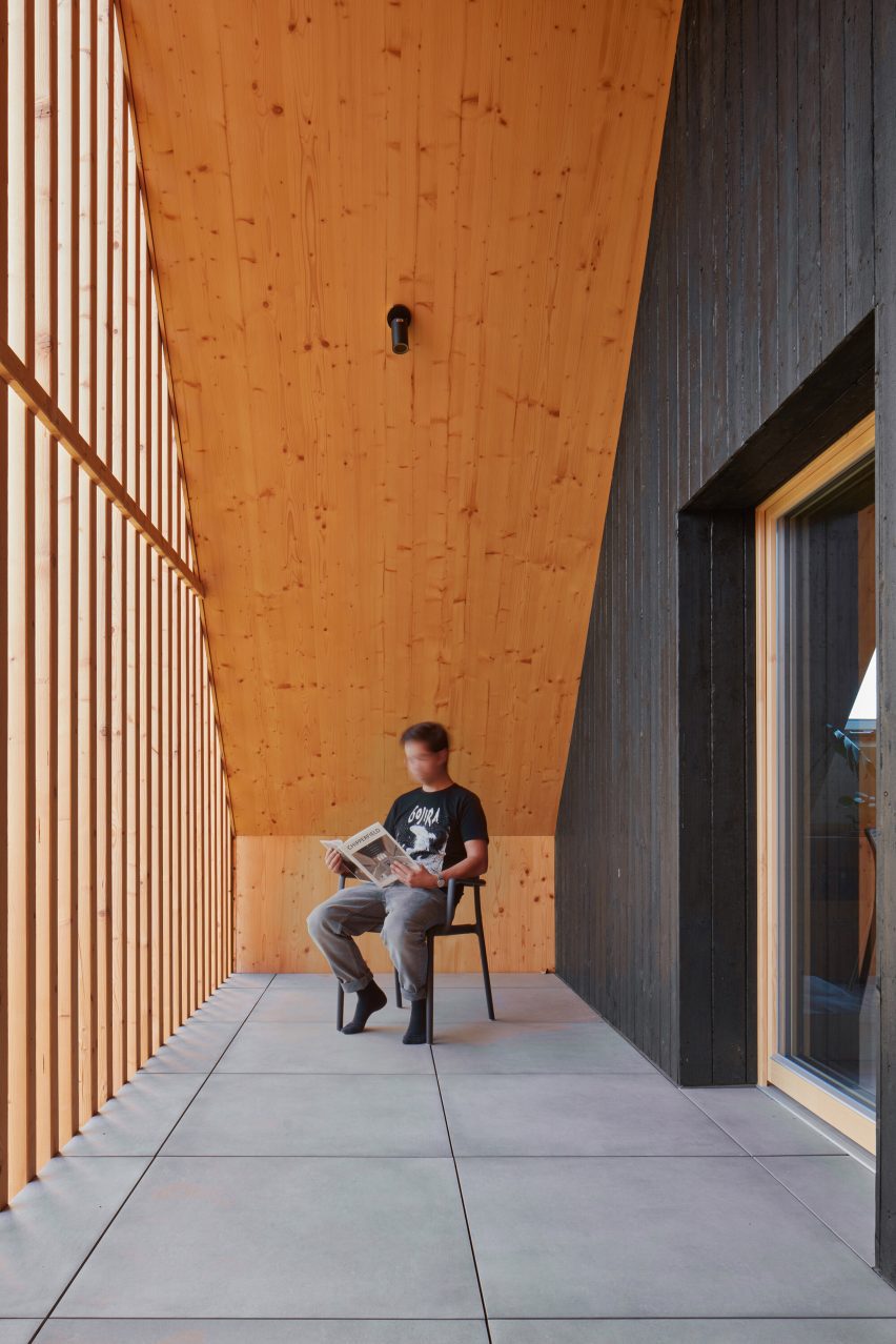 Sheltered balcony with timber battens at the Hut-inspired House by Atelier Hajný
