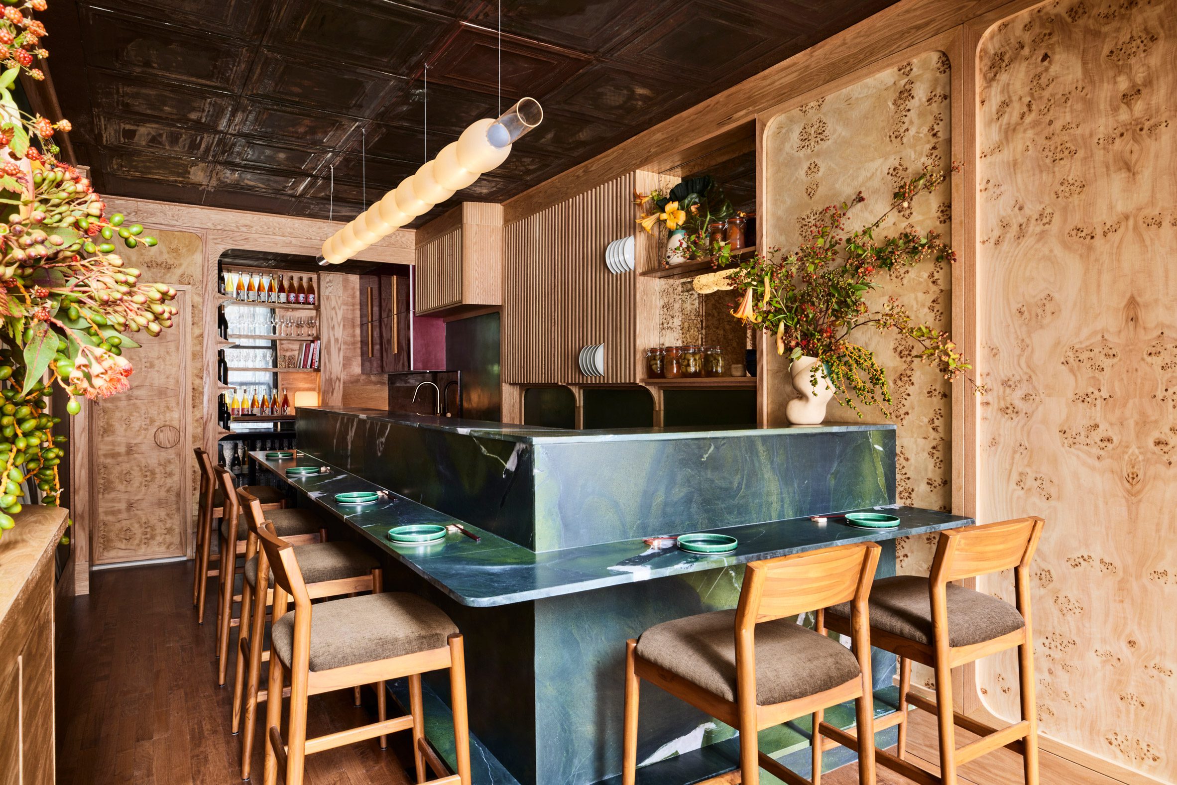 Small restaurant with dark blue-green counters and burl wood walls