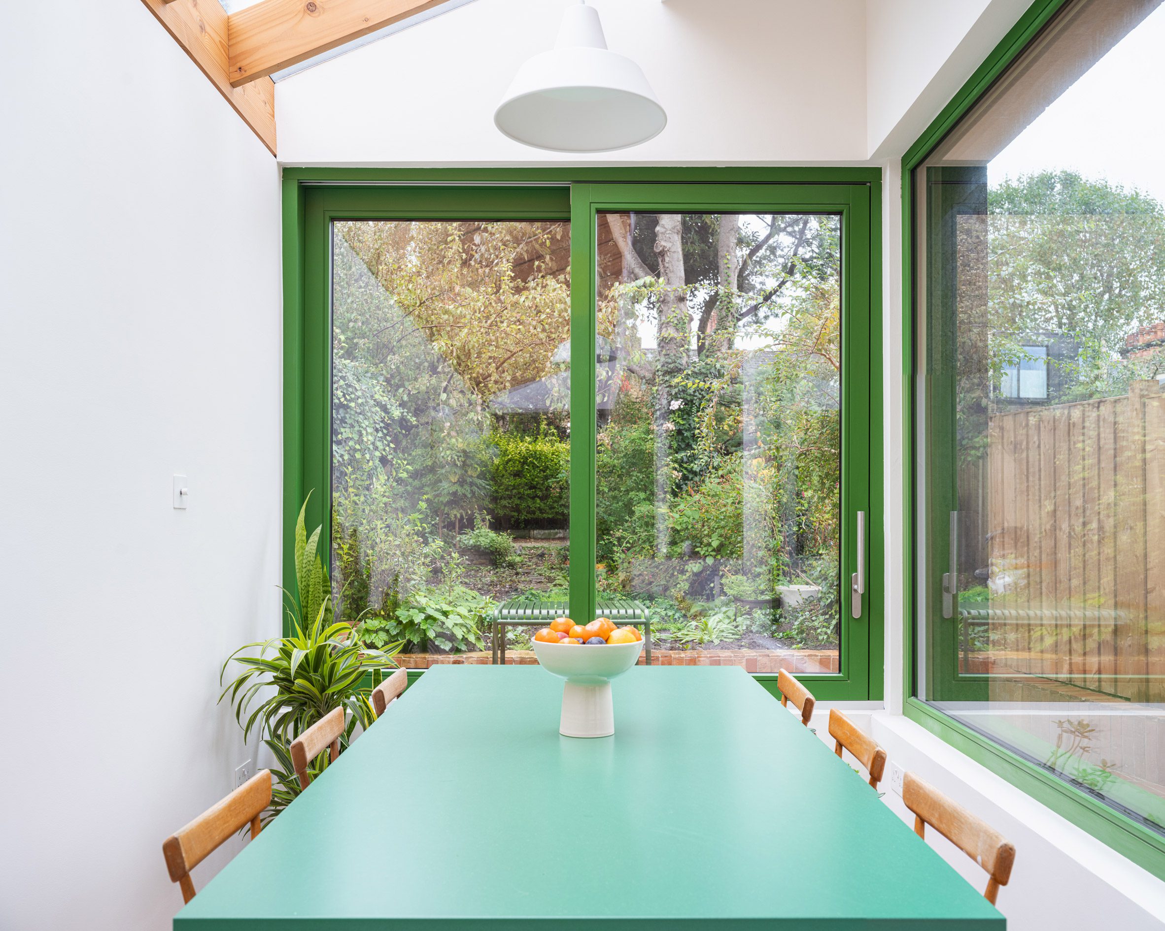 Dining area with green table and window frames