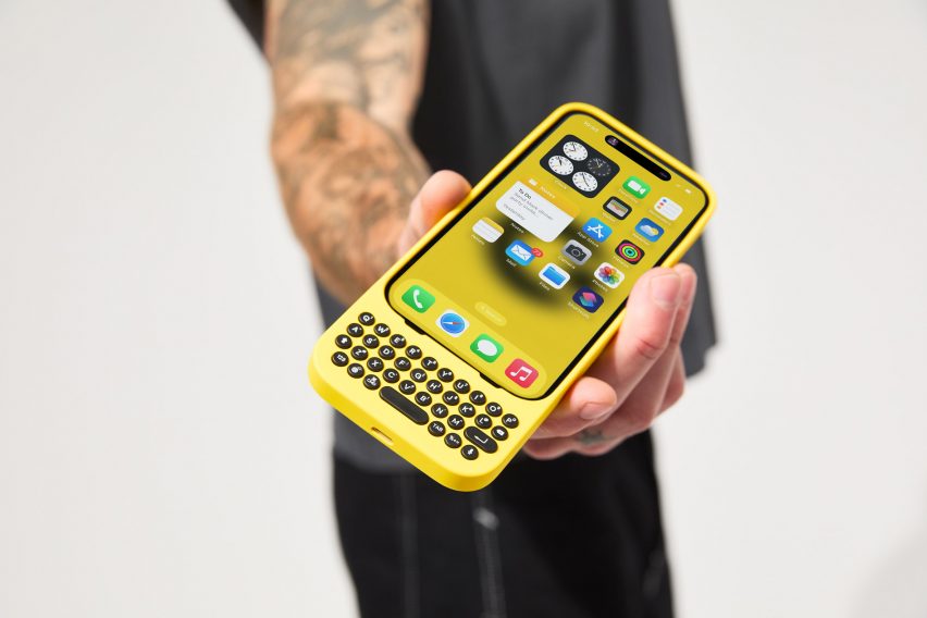 Person holding iPhone with yellow mechanical keyboard