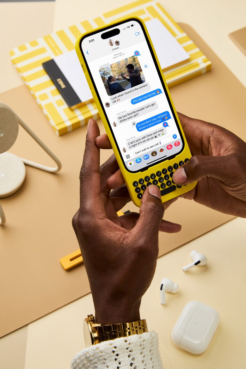Person using iPhone with yellow mechanical keyboard by Clicks Technology
