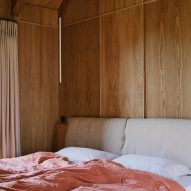 Wood-lined bedroom with pink bedding