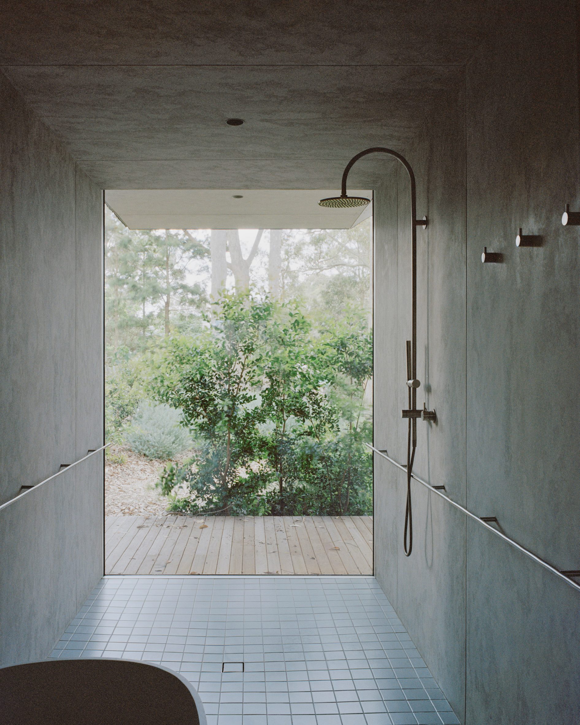 Bathroom with grab rails and glazed wall inside Mossy Point in New South Wales by Edition Office