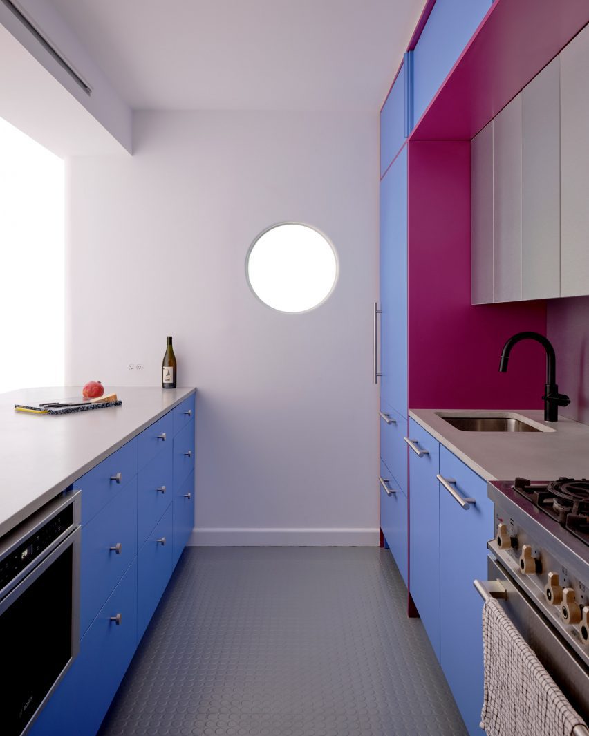 Kitchen with cabinets on two sides and a porthole in the end wall