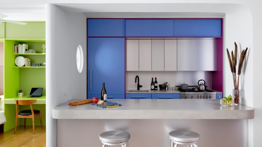 Blue and purple kitchen cabinets behind a concrete counter
