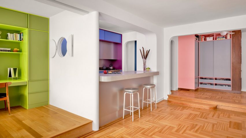 Apartment with green bedroom, blue kitchen and pink storage
