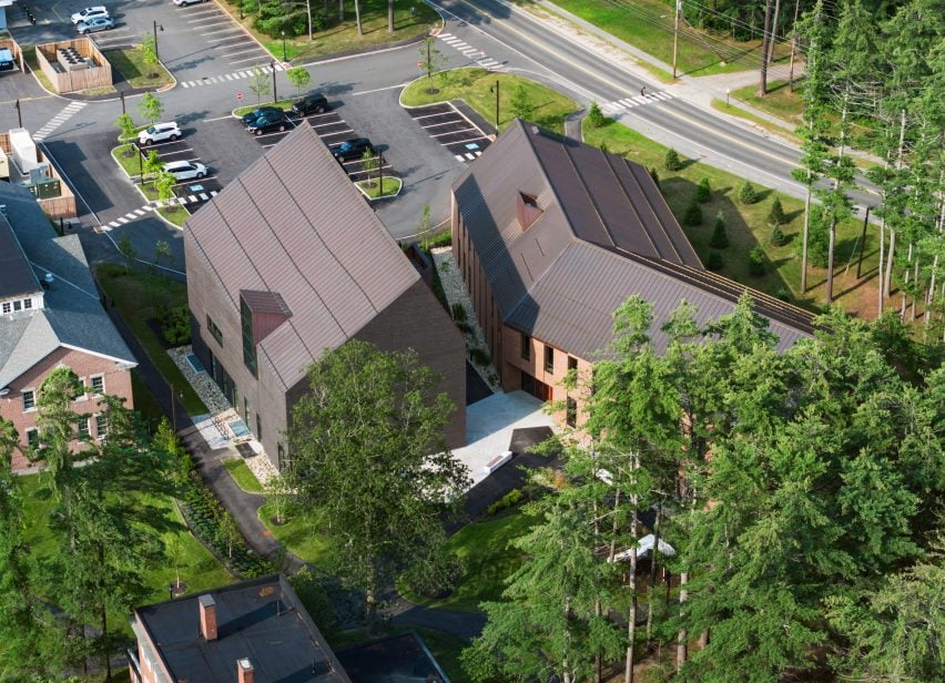 Gabled m، timber buildings in Maine from above with pine grove