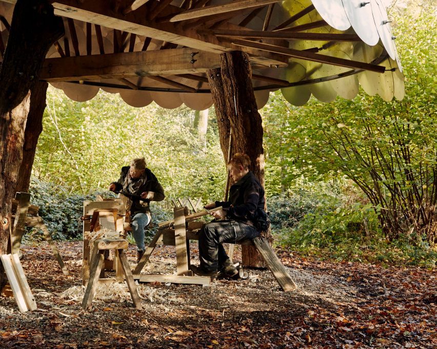 Oameni care lucrează în adăpostul pentru prelucrarea lemnului de la arboretul Westonbirt