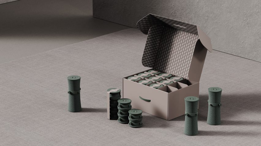 Image of an open carton storing a number of green coloured discs, which are shown in their popped-up, slightly hourglass-shaped cylindrical form outside of the box