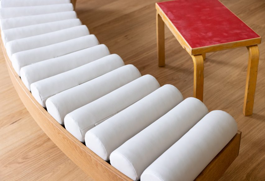 Close-up on a curved bench with a row of cylindrical seat pillows