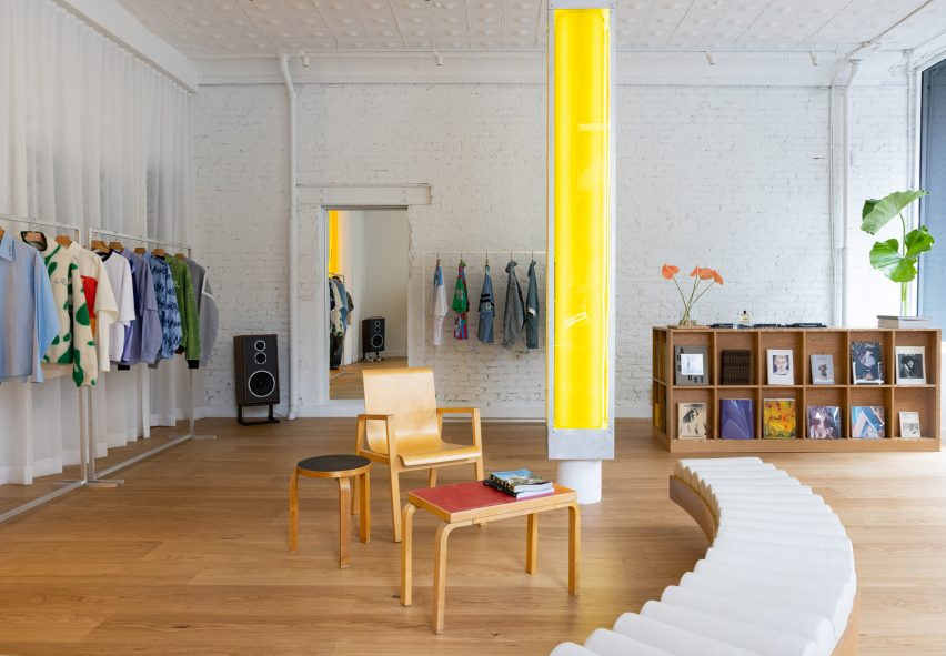 Store interior with white walls, wooden floors and a central yellow column
