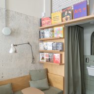 A corner with a couch, bookshelves and curtain