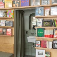 Bookshelves with a sink in the middle and a green curtain