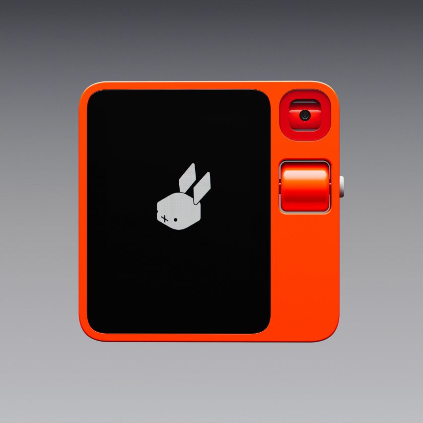 Image of the Rabbit R1 device front on, showing a bright orange square-shaped gadget with a screen on the left-hand side and a camera lens and scroll button on the right