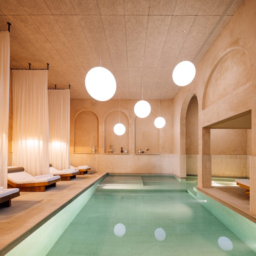 Spa with textured plaster walls, and globe-shaped lights over a large pool
