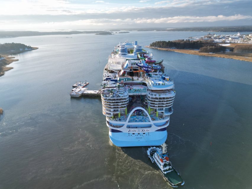 Photo of the back of a very large cruise ship with waterslides, pools and fun parks on top