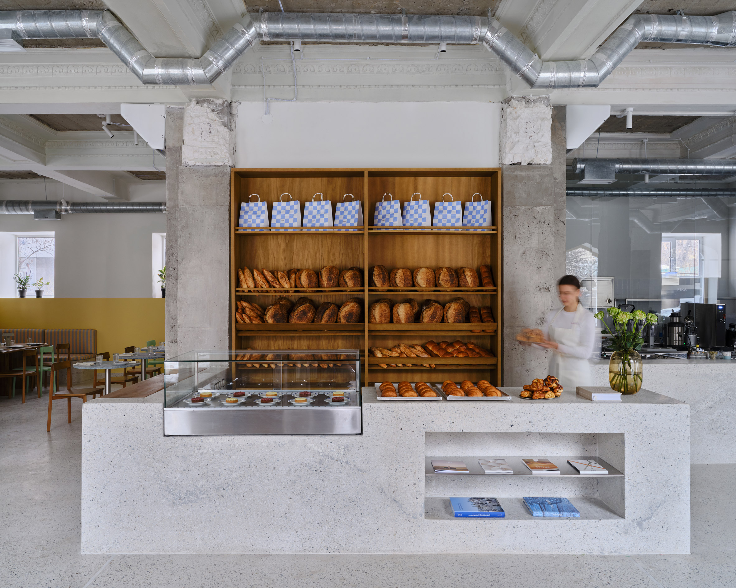Bench and baked goods display within FIKA Restaurant in Kazakhstan by NAAW Studio