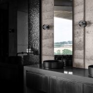 Bathroom with rammed earth walls and black sinks