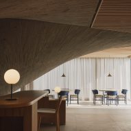 Dining tables alongside a curtained wall inside a brutalist restaurant in Spain by Zooco Estudio