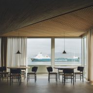 Dining tables overlooking views of the bay inside a brutalist restaurant in Spain by Zooco Estudio