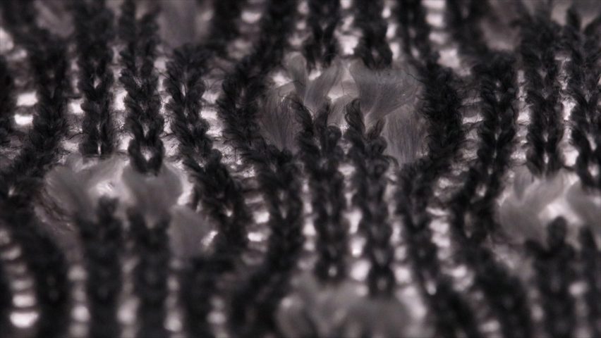 Close-up photo of yarn knitted together with some parts in a tight weave and other parts looking open and fluffy