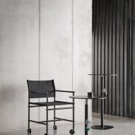 A black Able chair by Blå Station alongside two small round tables of varied heights