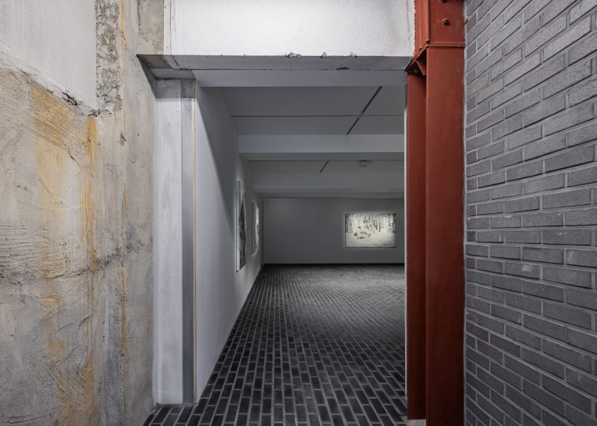 White gallery interior with grey brick floors