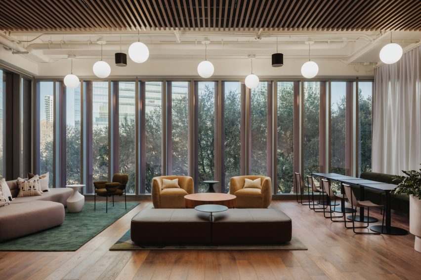 Globular lights with modern furniture and trees through glass windows in skyscraper