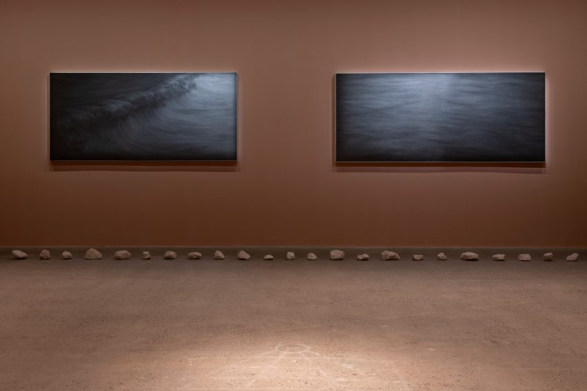 Graphite drawings on a brown exhibition wall